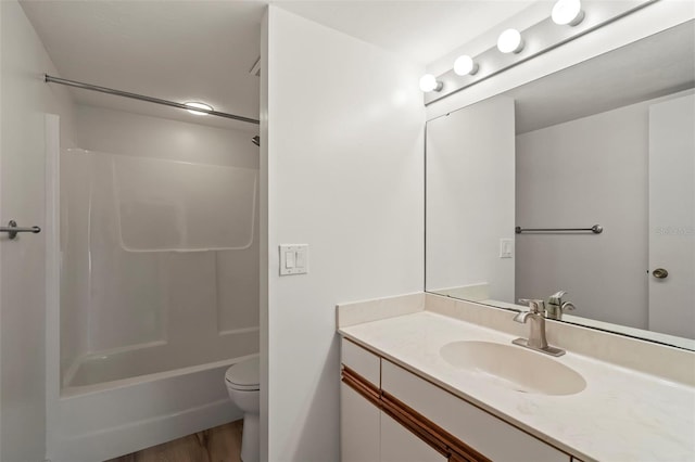 full bathroom with  shower combination, hardwood / wood-style floors, vanity, and toilet