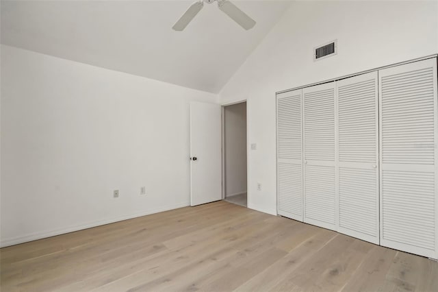 unfurnished bedroom featuring high vaulted ceiling, a closet, ceiling fan, and light wood-type flooring