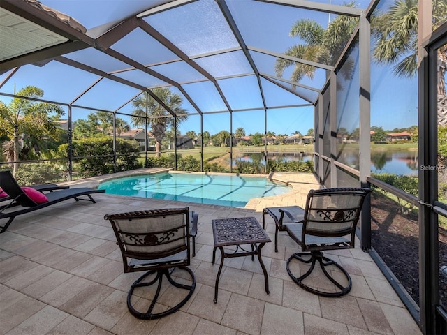 view of pool featuring a patio area, a water view, and glass enclosure