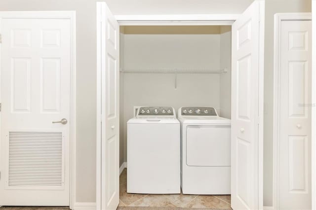 laundry area with light tile patterned floors and washing machine and dryer