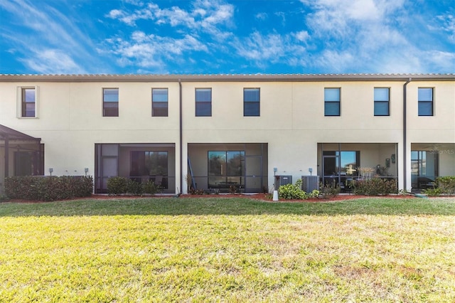 rear view of property featuring a yard and central air condition unit