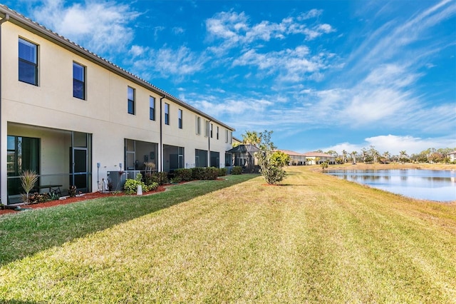 view of yard featuring central AC and a water view