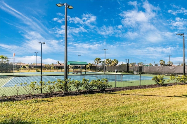 view of tennis court with a yard