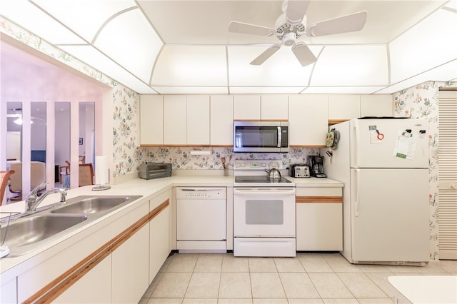 kitchen featuring white cabinetry, sink, light tile patterned floors, and white appliances