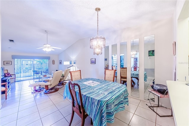 tiled dining space with ceiling fan with notable chandelier, vaulted ceiling, and a textured ceiling