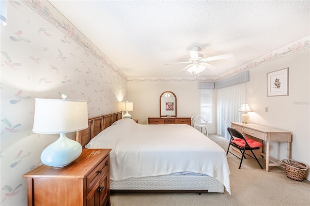 bedroom with light carpet, ceiling fan, and a textured ceiling