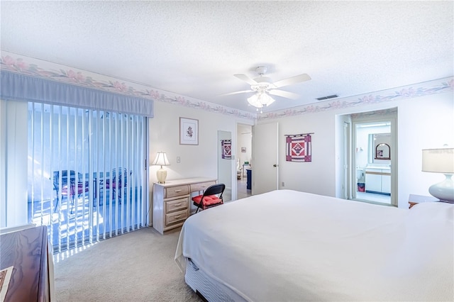 bedroom with ceiling fan, light colored carpet, and a textured ceiling