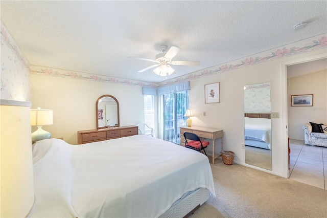 carpeted bedroom featuring ceiling fan and a textured ceiling