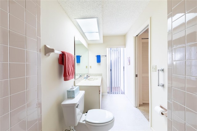 bathroom with a skylight, vanity, a textured ceiling, and toilet