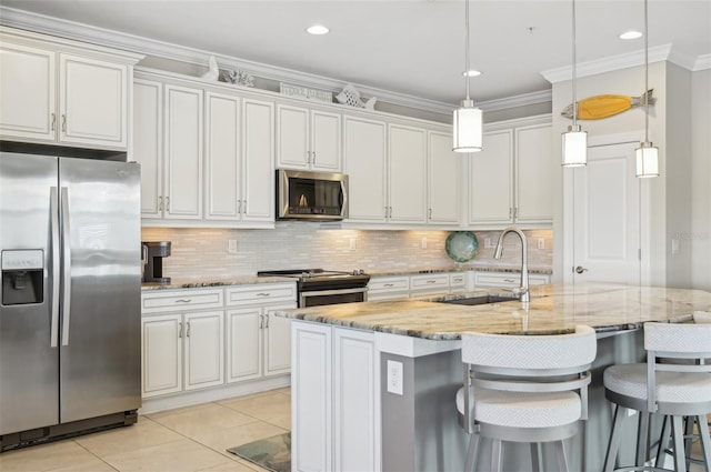 kitchen with hanging light fixtures, light stone countertops, appliances with stainless steel finishes, and a center island with sink