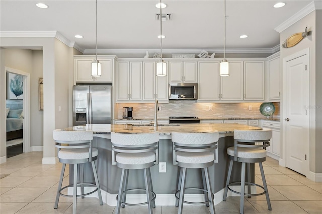 kitchen featuring white cabinetry, hanging light fixtures, light tile patterned floors, stainless steel appliances, and a center island with sink