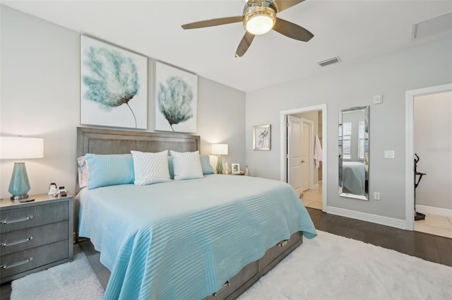 bedroom with connected bathroom, hardwood / wood-style floors, and ceiling fan