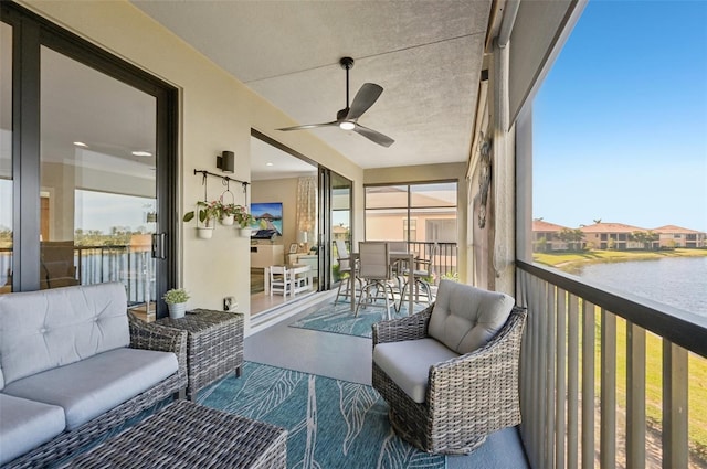 sunroom with a water view and ceiling fan