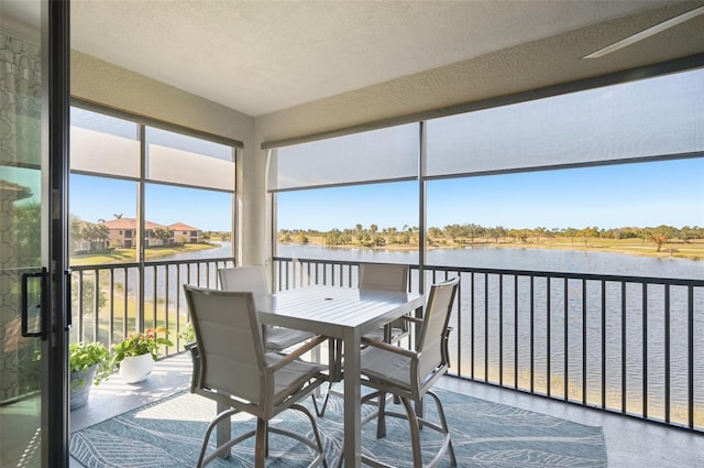 sunroom / solarium featuring a water view