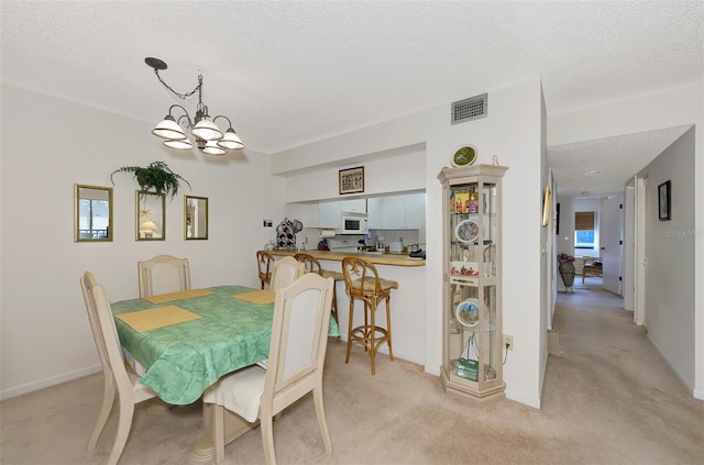 carpeted dining space featuring a notable chandelier and a textured ceiling