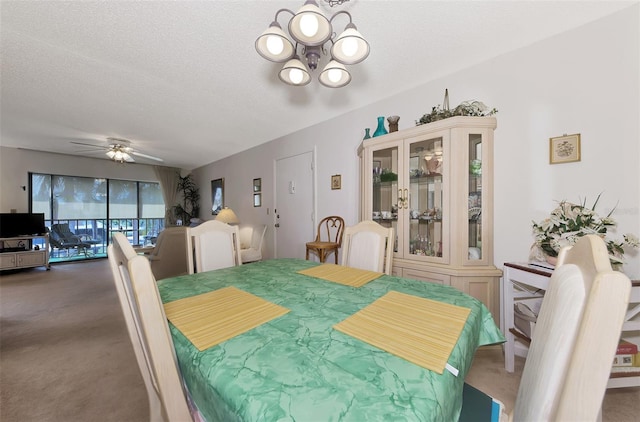 dining space featuring carpet flooring, ceiling fan with notable chandelier, and a textured ceiling