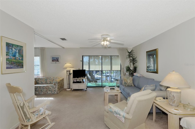 living room with a healthy amount of sunlight, carpet flooring, and a textured ceiling