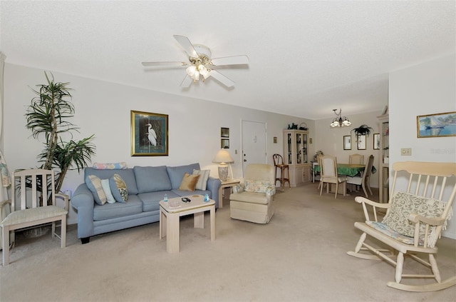 living room with ceiling fan with notable chandelier, carpet floors, and a textured ceiling