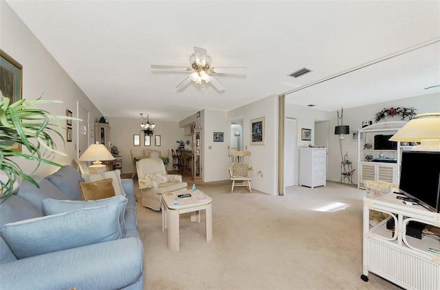 carpeted living room with ceiling fan with notable chandelier