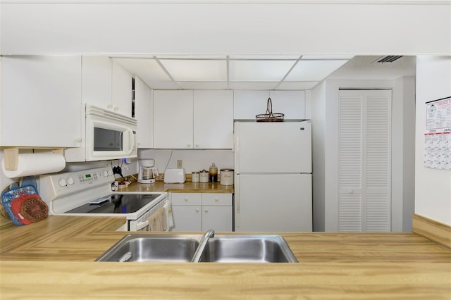 kitchen featuring white cabinetry, white appliances, sink, and butcher block countertops