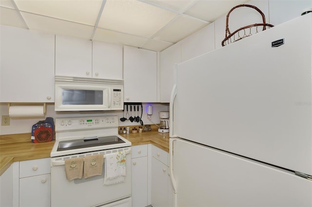 kitchen with butcher block counters, white appliances, a paneled ceiling, and white cabinets