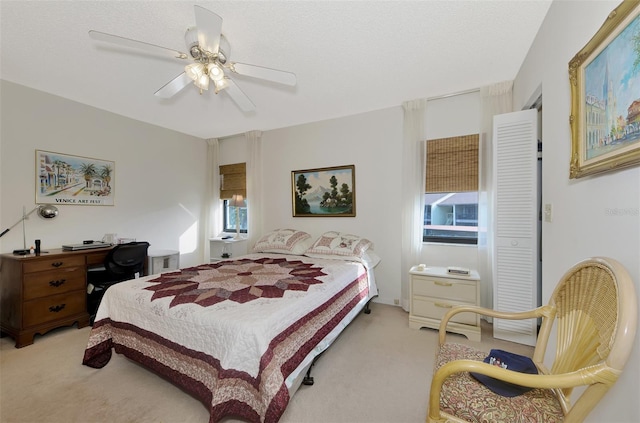 carpeted bedroom with ceiling fan and a textured ceiling