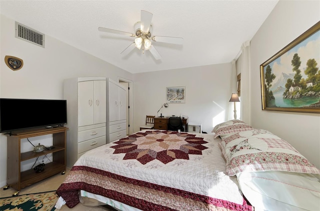 carpeted bedroom featuring ceiling fan and a textured ceiling