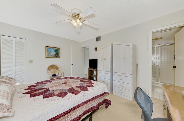 bedroom featuring ceiling fan, connected bathroom, light carpet, and a textured ceiling