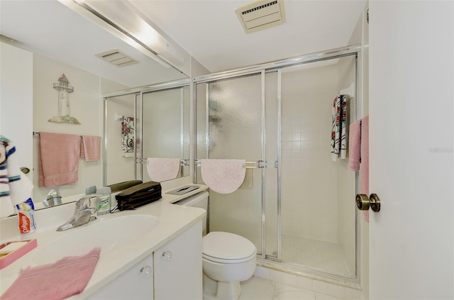 bathroom with vanity, a shower with shower door, and toilet