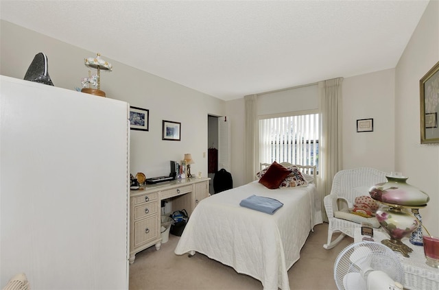 bedroom featuring light carpet and a textured ceiling