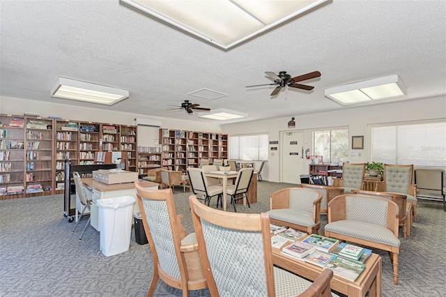 dining room featuring ceiling fan, carpet floors, and a textured ceiling