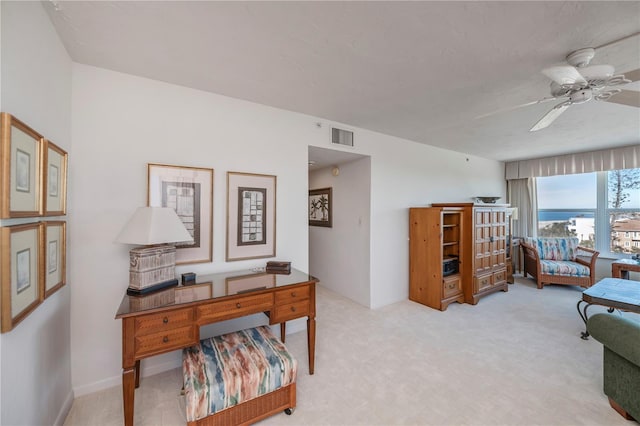 carpeted office space with ceiling fan