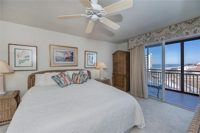 bedroom with a water view, ceiling fan, and access to exterior