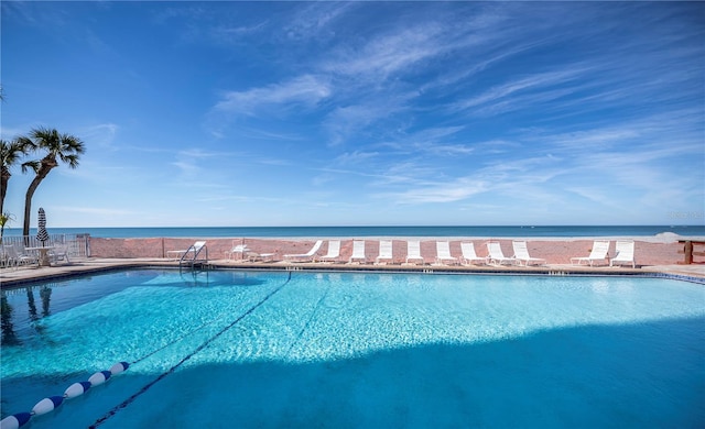 view of swimming pool featuring a water view