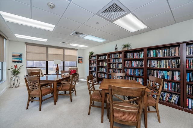 carpeted dining space featuring a paneled ceiling