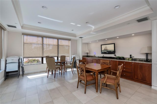 dining space featuring a raised ceiling and ornamental molding