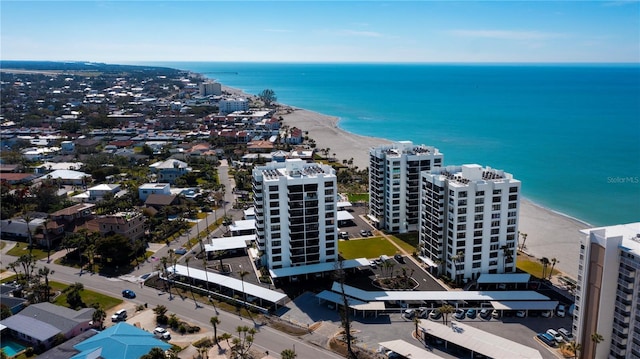 birds eye view of property featuring a water view and a beach view