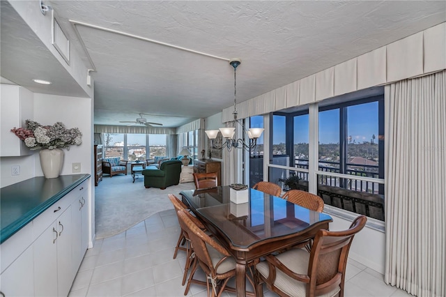627 Alhambra Rd Unit 601, Venice, FL 34285 - dining space featuring light tile patterned flooring, a chandelier, light colored carpet, and ceiling fan
