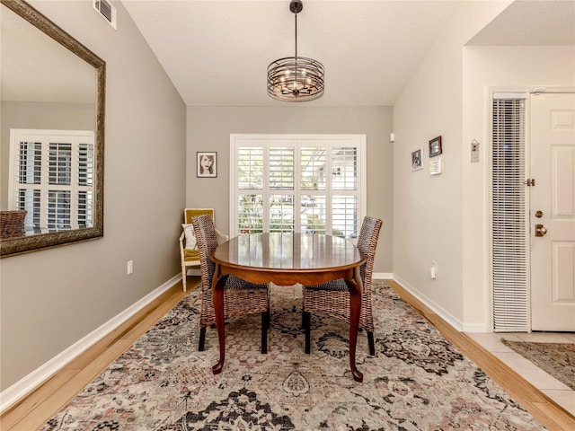 dining area with an inviting chandelier and wood-type flooring