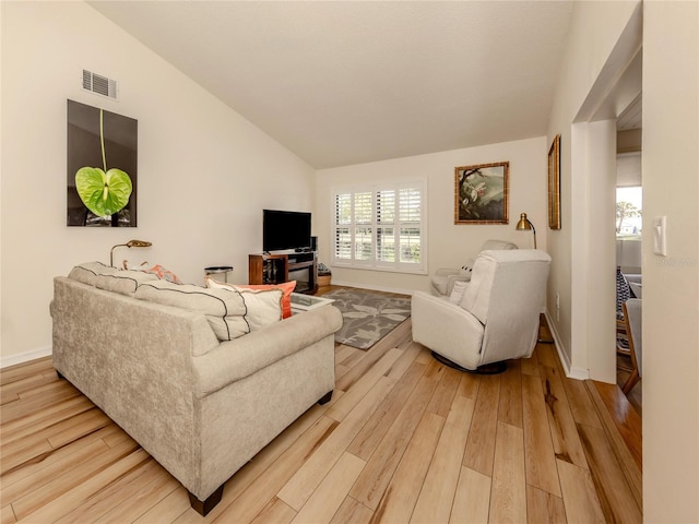 living room featuring hardwood / wood-style flooring and vaulted ceiling