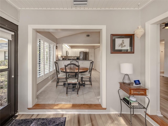 dining area with lofted ceiling and light hardwood / wood-style flooring