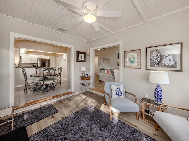 living area with wood ceiling, light hardwood / wood-style flooring, and ceiling fan