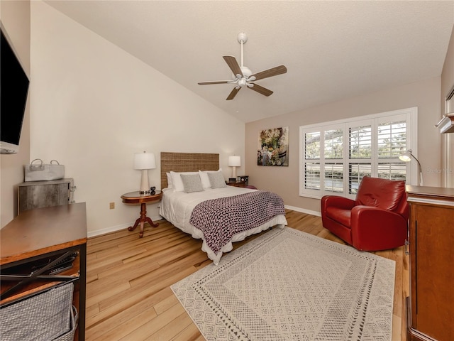 bedroom featuring light hardwood / wood-style flooring, vaulted ceiling, and ceiling fan