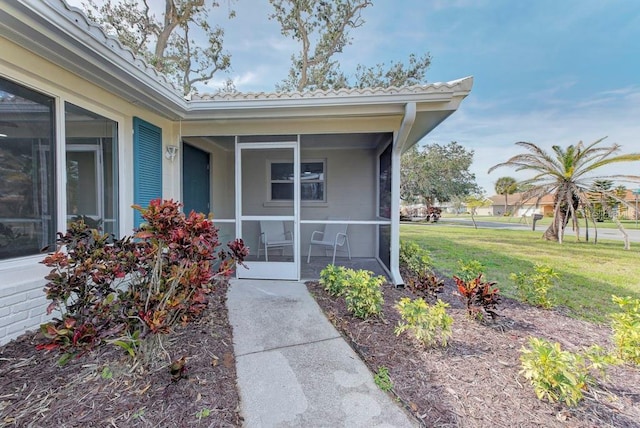 view of exterior entry with a yard