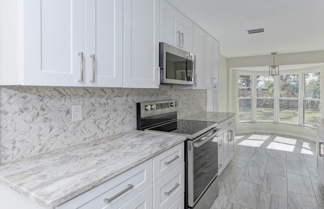 kitchen with backsplash, light stone counters, appliances with stainless steel finishes, marble finish floor, and white cabinetry