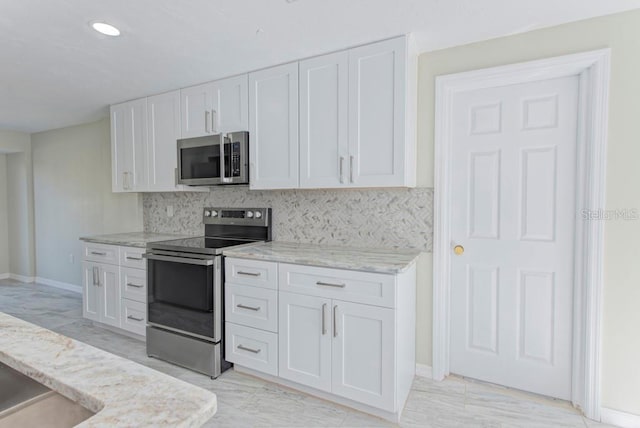 kitchen with tasteful backsplash, light stone counters, recessed lighting, white cabinets, and stainless steel appliances