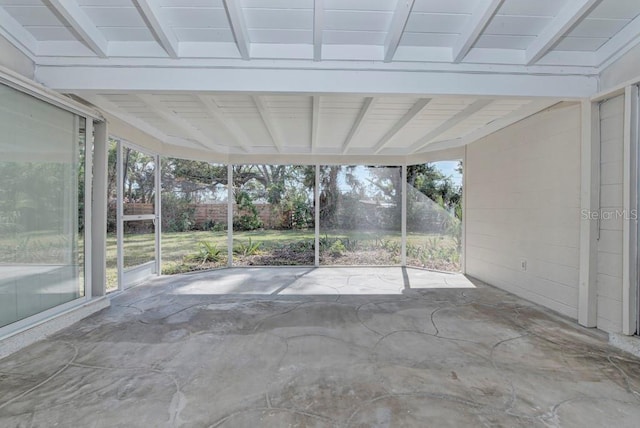 unfurnished sunroom featuring beamed ceiling