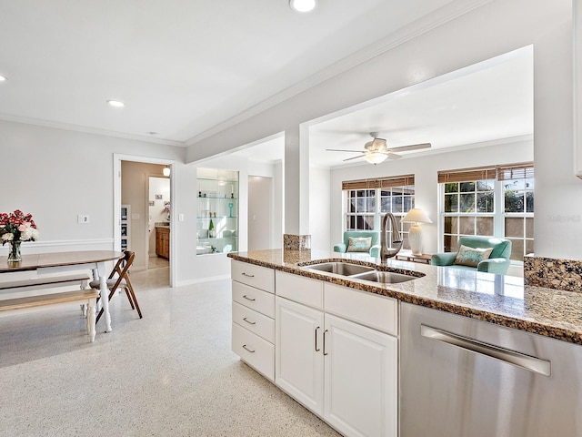 kitchen with white cabinetry, sink, stainless steel dishwasher, and dark stone counters