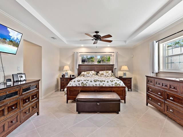 tiled bedroom featuring ceiling fan, ornamental molding, and a tray ceiling