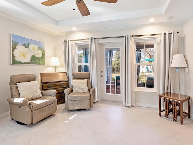 living area with light tile patterned flooring, ceiling fan, and a raised ceiling